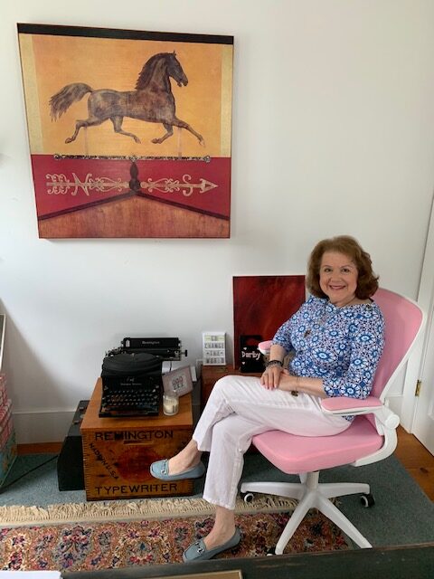 Darby Hobbs sitting in a pink office chair